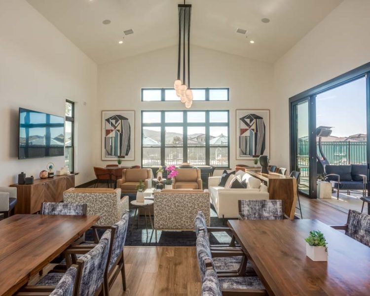 A stylish clubhouse with a dining area, comfortable lounge seating, and large windows offering outdoor views.