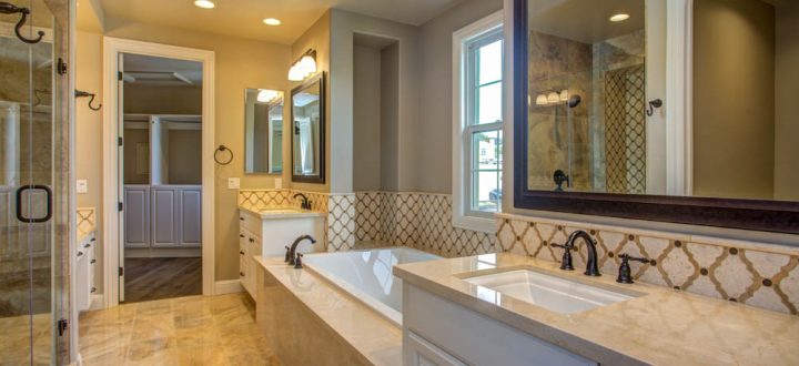 Spacious bathroom boasting custom tile work on the floor and backsplash, a large mirror over a double vanity, and a glass shower, illustrating sophisticated design and luxury.