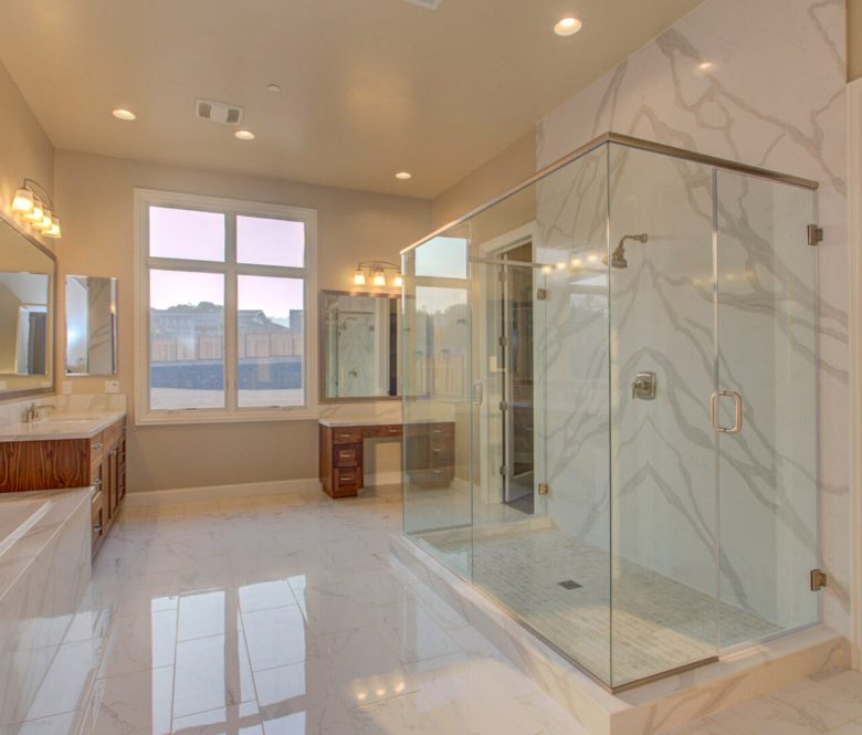 Spacious master bathroom featuring floor-to-ceiling marble, a large glass-enclosed shower, dual vanity sinks, and modern fixtures, reflecting high-end comfort and sophistication.