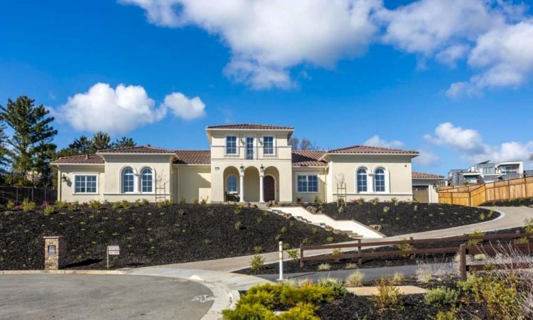 Exterior of a luxurious hilltop home with a Mediterranean style, white stucco, and panoramic views, demonstrating upscale exterior remodeling.